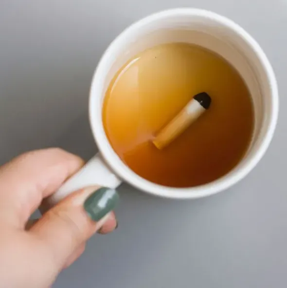 Tasse mit ekliger Attrappe am Boden - Zigarette
